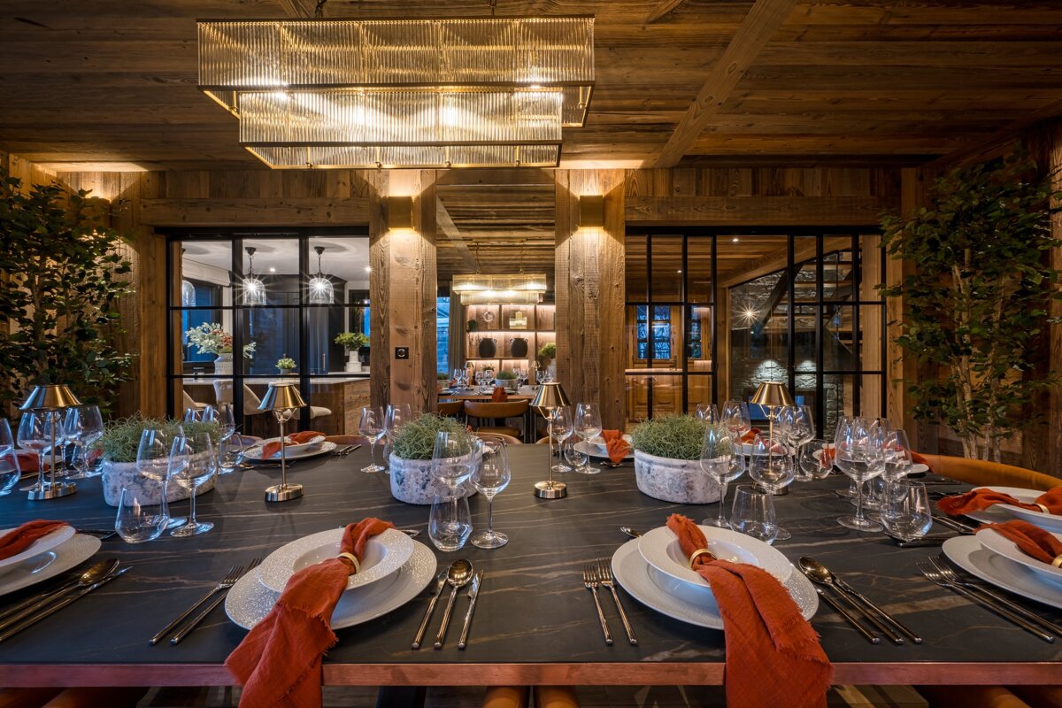 A dining room table with plates and utensils on it