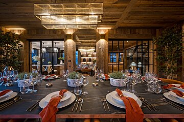 A dining room table with plates and utensils on it