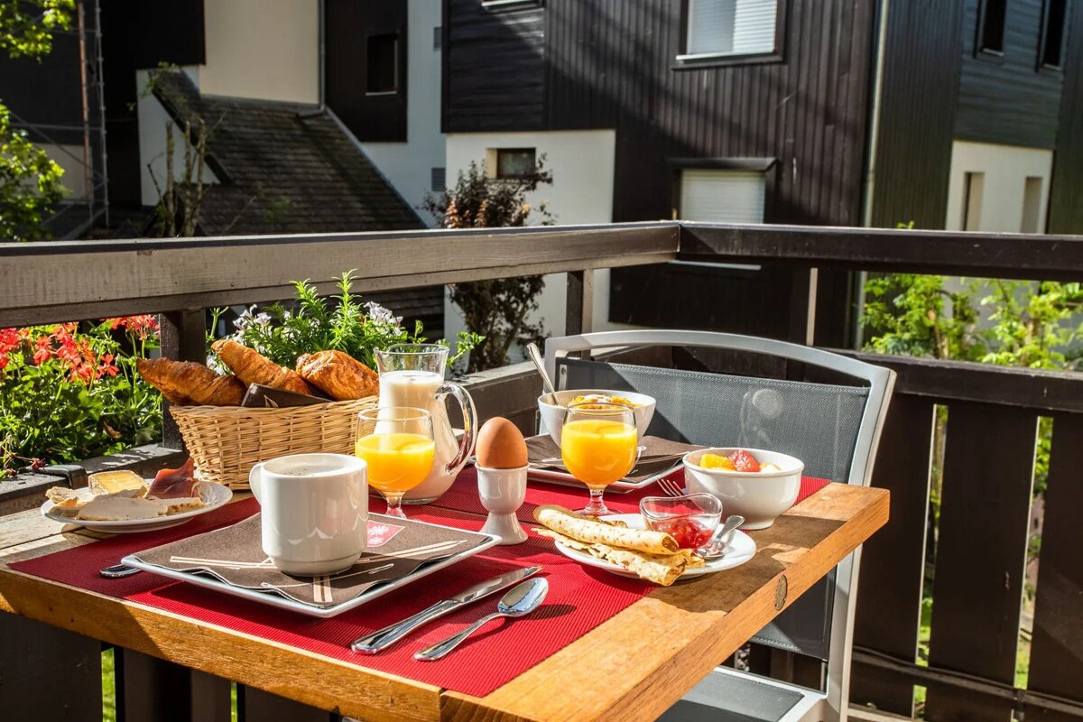 A table with plates of food and glasses of orange juice on it