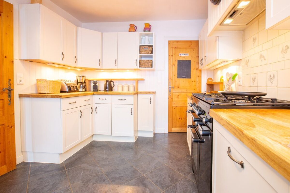 A kitchen with white cabinets and a door that says ' a ' on it