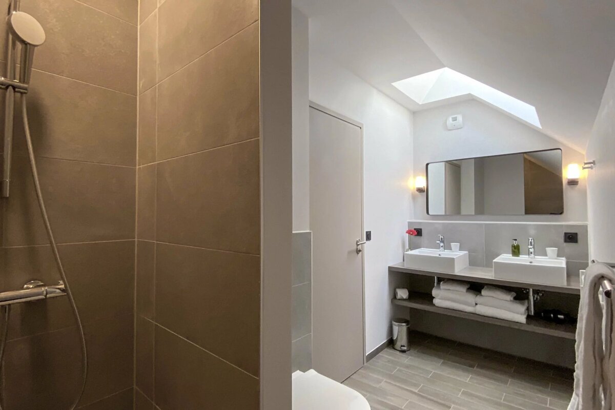 A bathroom with two sinks and a skylight