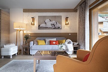 A living room with a couch a chair and a chess board