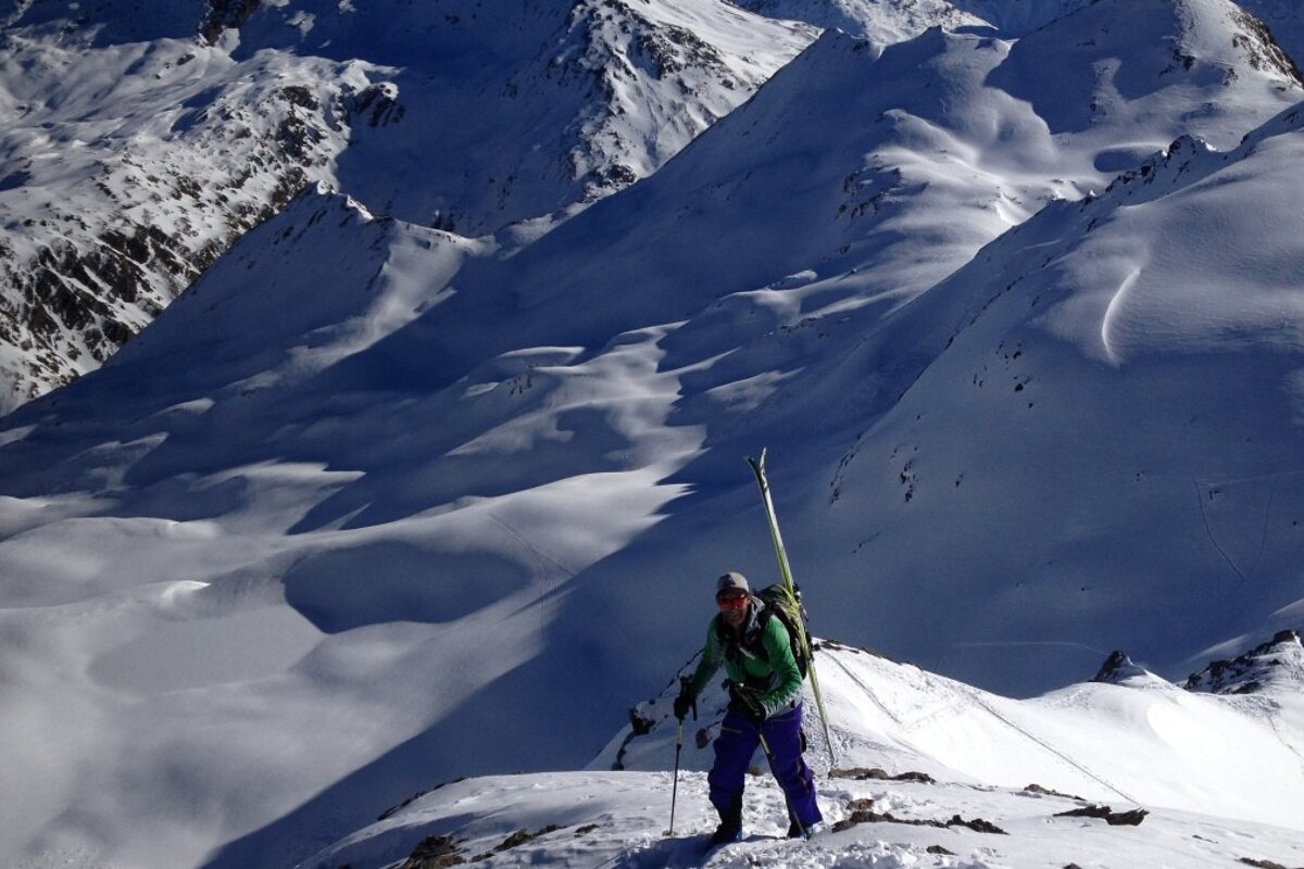 A person standing on top of a snow covered mountain