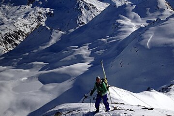 A person standing on top of a snow covered mountain