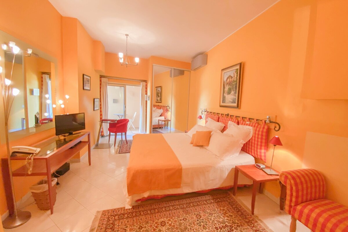 A bedroom with orange walls and a large bed
