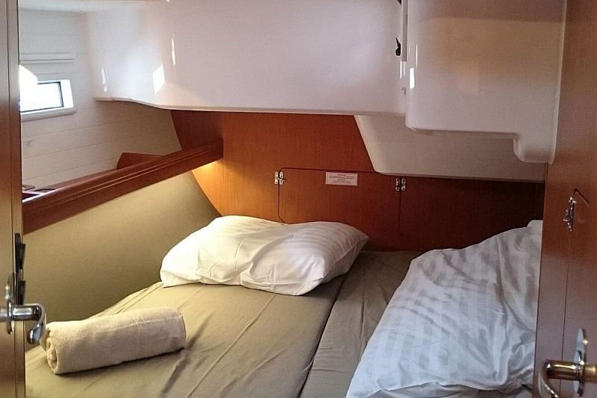 A bed with a pillow and two towels on it