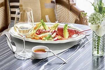 A plate of food and a glass of wine on a table