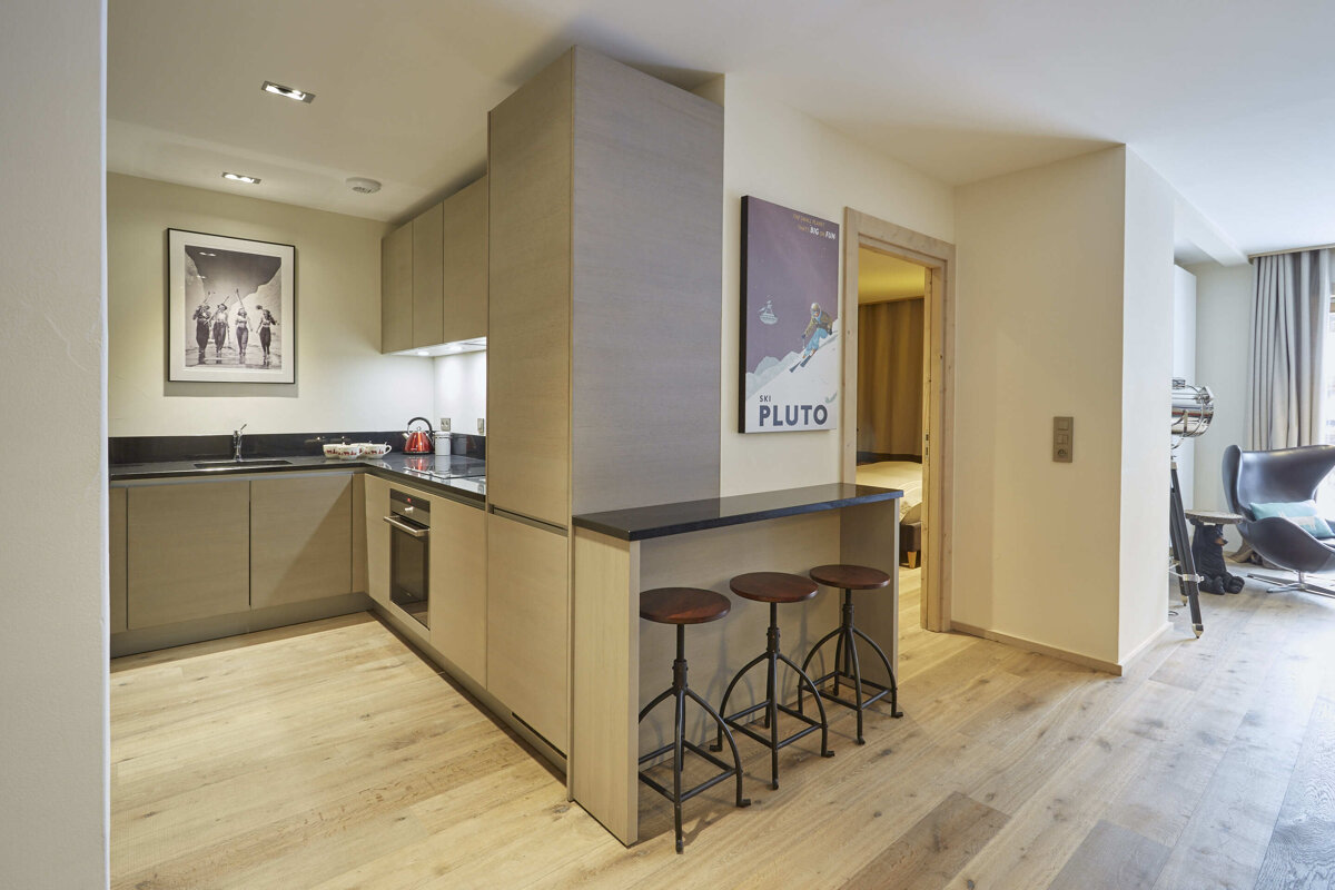 A kitchen with a picture on the wall that says pluto