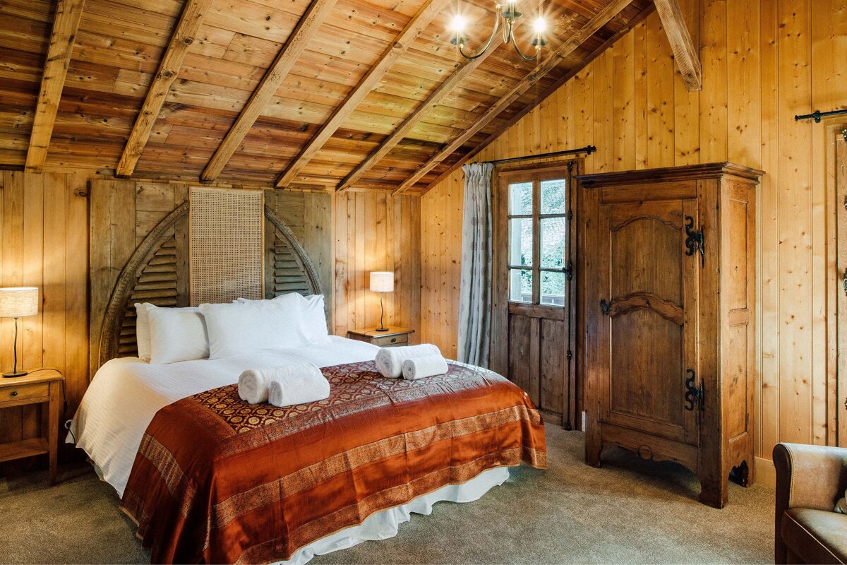 A bedroom with a wooden ceiling and a bed
