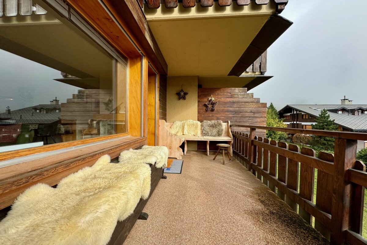 A balcony with a wooden bench and a star on the wall