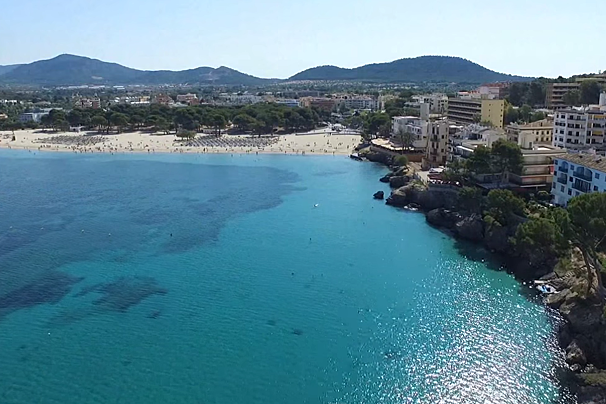 An aerial view of a beach with mountains in the background