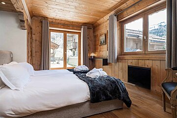 A bedroom with two beds and a large window