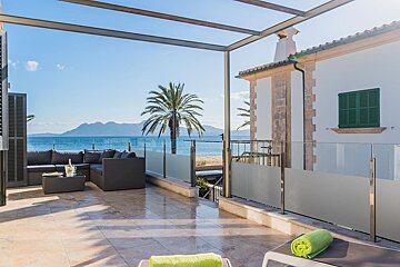 A balcony with a view of the ocean and mountains