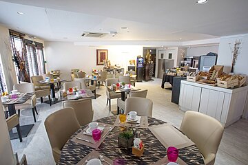 A dining room with tables and chairs set up for breakfast