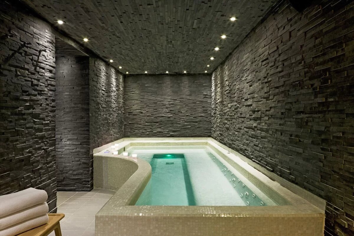 A bathtub in a room with a brick wall