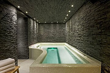 A bathtub in a room with a brick wall