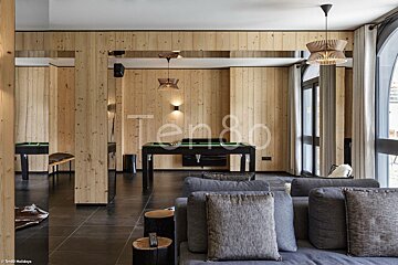 A living room with wood paneling and a pool table that says ten80