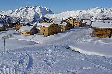 A ski resort covered in snow with a mountain in the background