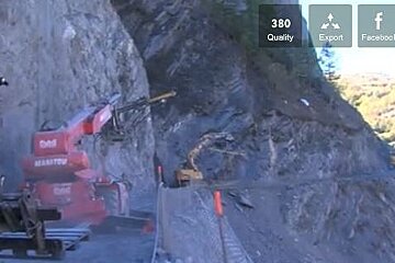 diggers building a small road on the side of the mountain