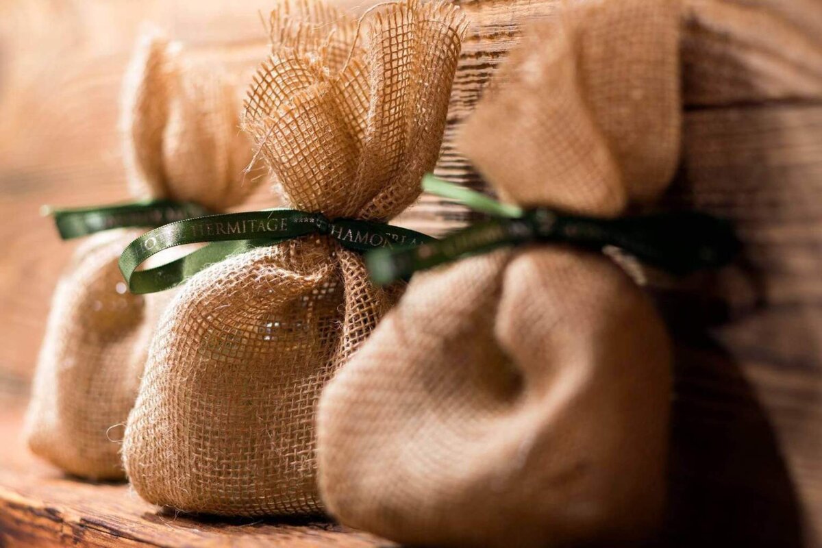 Three burlap bags with a green ribbon that says