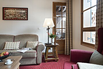 A living room with a couch a chair and a lamp