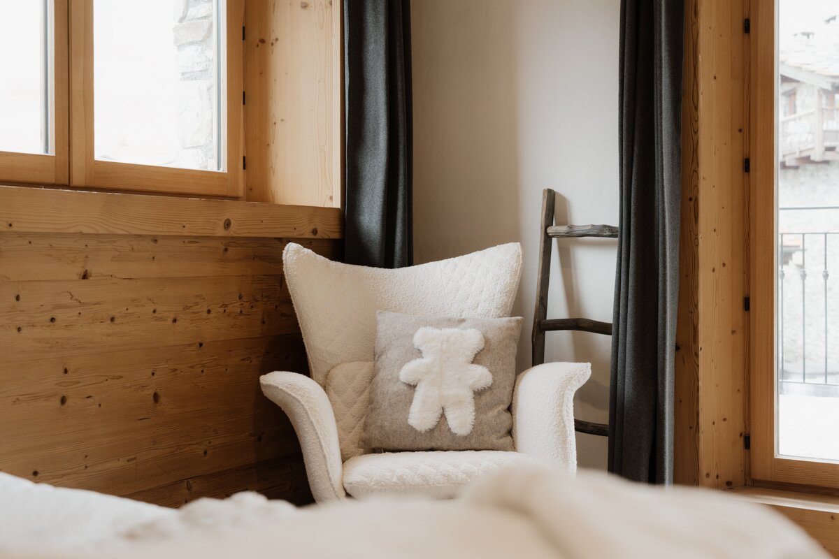 A white chair with a teddy bear pillow on it