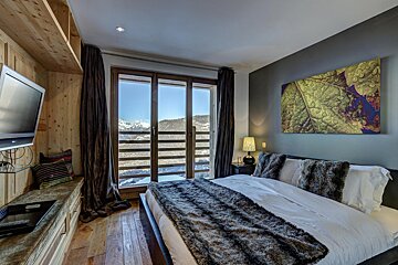 A bedroom with a painting on the wall above the bed
