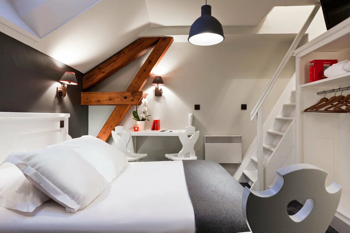 A bedroom with a staircase and a desk