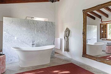 A bathroom with two tubs and a large mirror