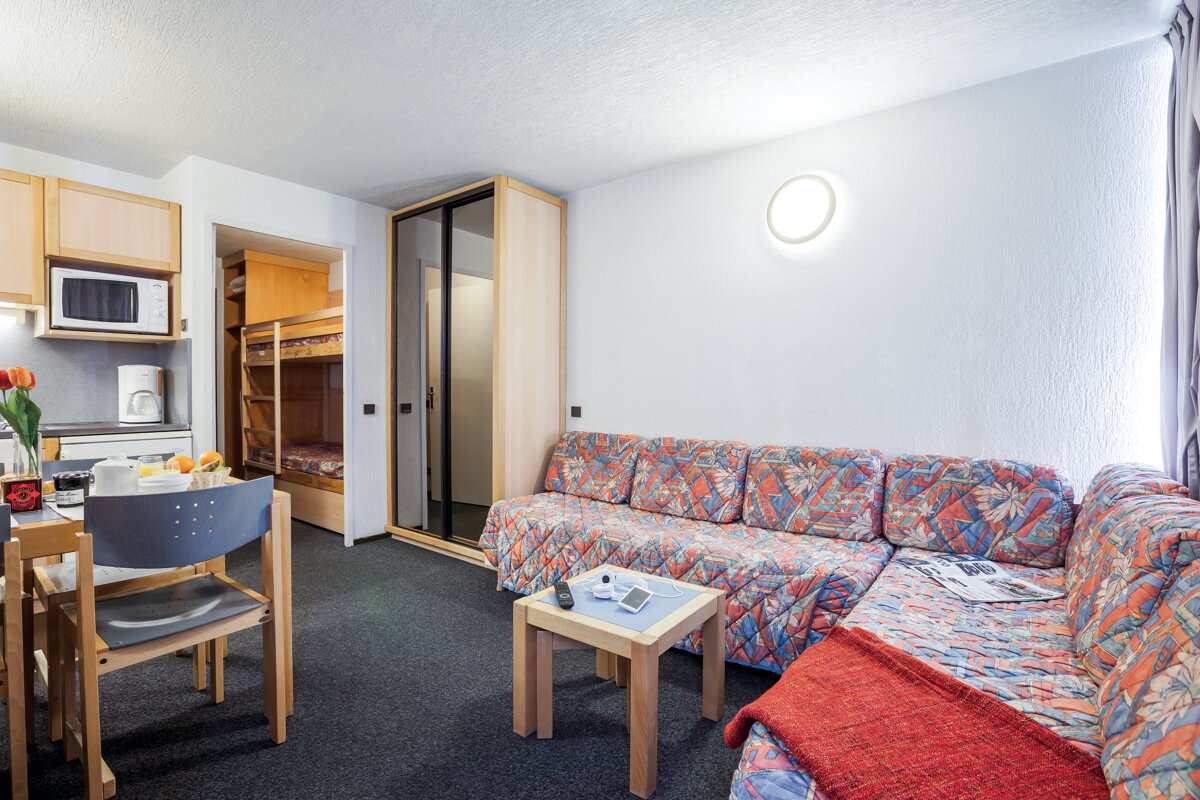 A living room with a couch and a table with a magazine on it