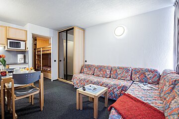 A living room with a couch and a table with a magazine on it