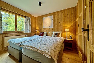 A bedroom with two beds and a painting on the wall