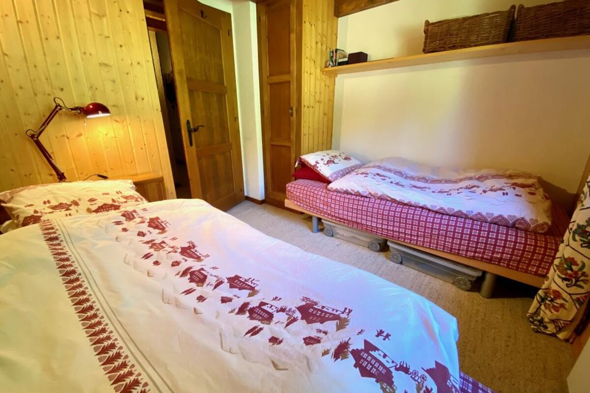 A bed with a red and white blanket that says ' switzerland ' on it