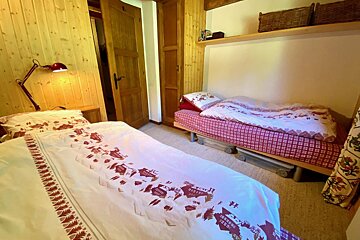 A bed with a red and white blanket that says ' switzerland ' on it