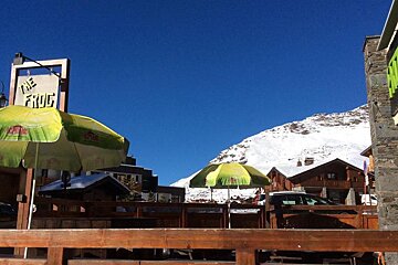 a bar terrace with green parasols