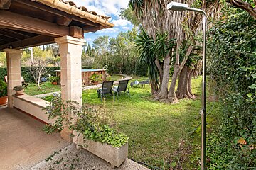 A patio with a planter and a shower in the backyard