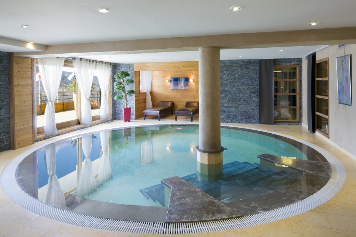 A large indoor swimming pool with stairs leading to it
