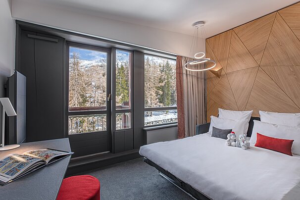 A hotel room with a bed and a large window