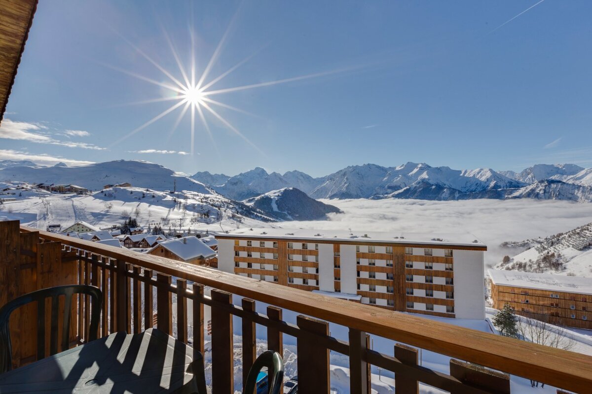 The sun shines brightly over the snowy mountains