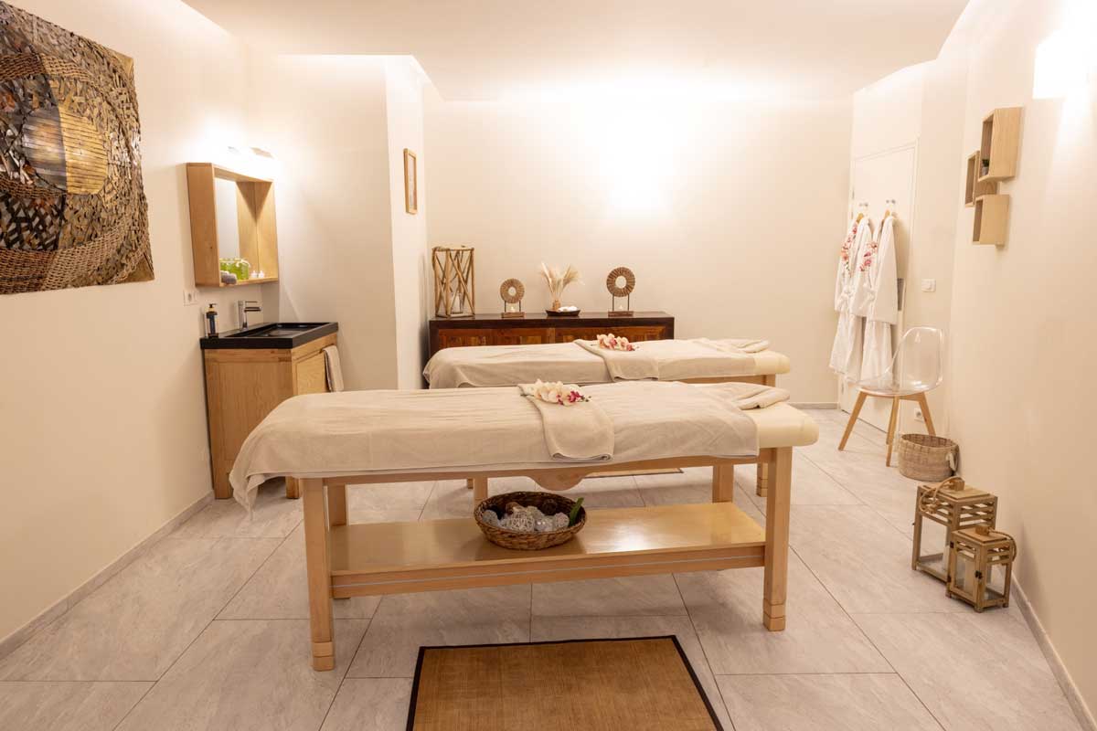 A room with two massage tables and a sink