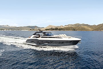 A boat is floating on a body of water with mountains in the background