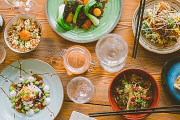 A wooden table topped with plates of food and a bottle of wine