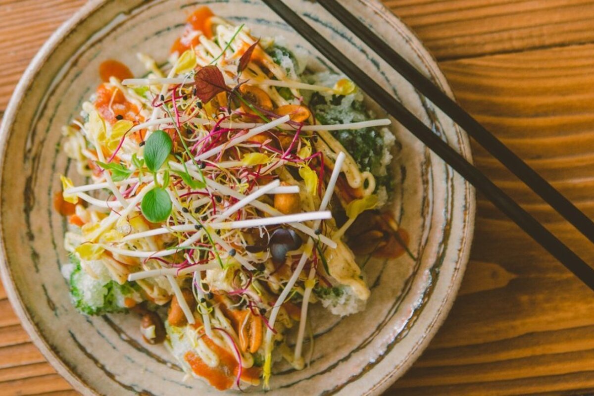 A plate of food with chopsticks on a wooden table