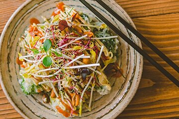 A plate of food with chopsticks on a wooden table