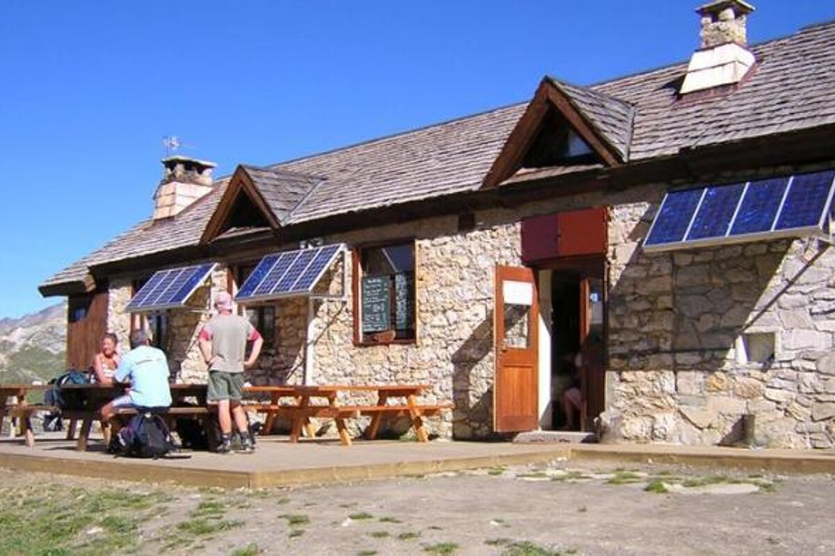 a stone refuge with picnic benches in tignes