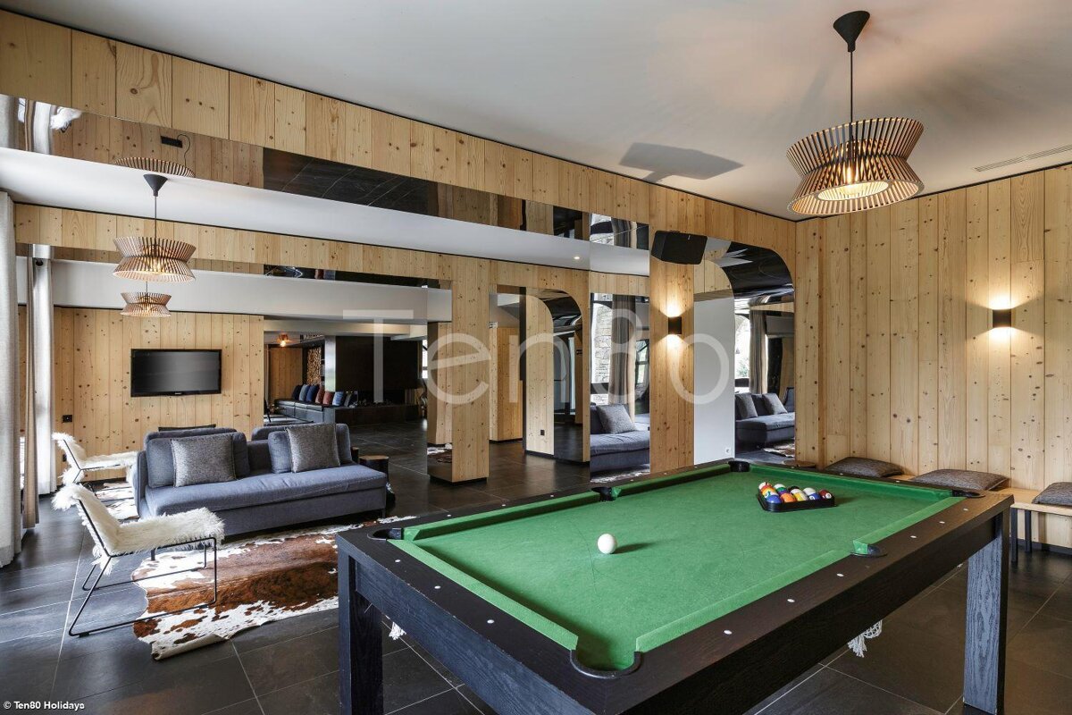 A pool table in a living room with the word tempo on the wall