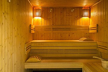 A wooden sauna with a bucket in the corner