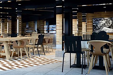 A restaurant with tables and chairs and a picture of a mountain on the wall