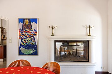 A fireplace with a painting on the wall above it