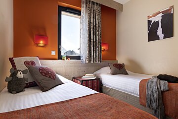 A bedroom with two beds and a picture of a cow on the wall